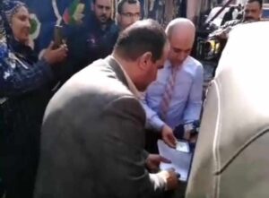 رئيس لجنة يساعد سيدة من ذوي الاحتياجات الخاصة للتصويت في العمليه الانتخابية بالقليوبية