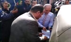 رئيس لجنة يساعد سيدة من ذوي الاحتياجات الخاصة للتصويت في العمليه الانتخابية بالقليوبية