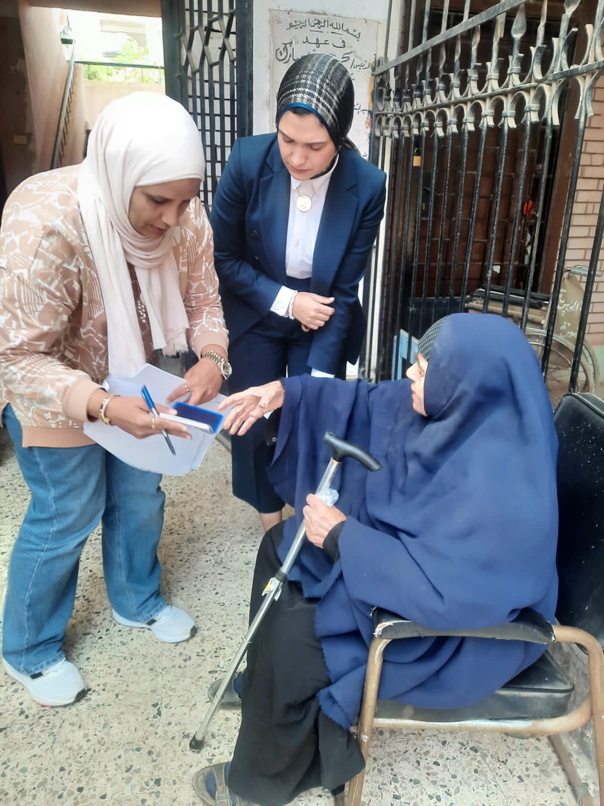 مستشارة تساعد مسنة علي الادلاء بصوتها في الانتخابات مستشارة تساعد مسنة علي الادلاء بصوتها في الانتخابات